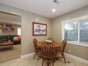 Dining space with baseboards, visible vents, and light tile patterned floors