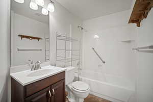 Bathroom with toilet, vanity, tub / shower combination, and visible vents