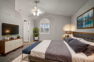 Bedroom featuring baseboards, visible vents, vaulted ceiling, and light carpet