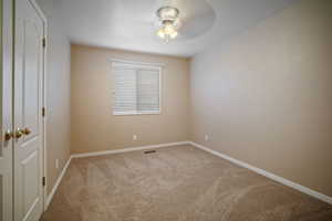 Carpeted empty room with baseboards and ceiling fan
