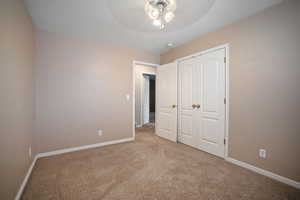 Unfurnished bedroom featuring baseboards, ceiling fan, a closet, and carpet floors