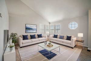 Living room featuring high vaulted ceiling, baseboards, and visible vents