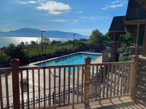 Pool featuring a mountain view, fence, and a patio area
