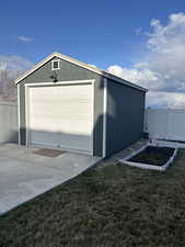Garage with a garden, driveway, and fence
