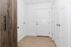 Entryway with light wood-style flooring and baseboards