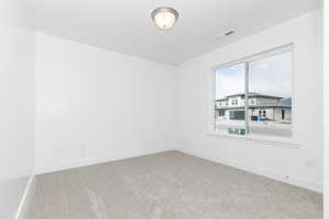 Carpeted spare room with baseboards and visible vents