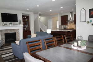 Dining space with stairs, a high end fireplace, and recessed lighting