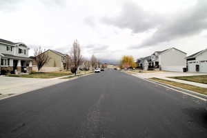 View of street featuring curbs, sidewalks, and a residential view