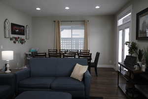 Living room featuring, dark wood-style floors, a healthy amount of sunlight, and recessed lighting