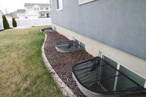 View of yard featuring safety window well grates.