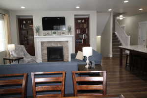 Living room with a premium fireplace, recessed lighting, stairs, and wood finished floors