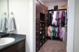 Large walk-in master bedroom closet with built-in shelves and drawers.