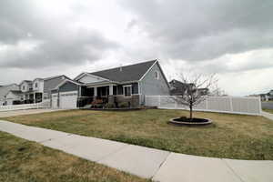 Side View of home with a front lawn and beautiful white vinyl fence