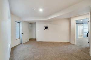 Carpeted empty room with a barn door and recessed lighting