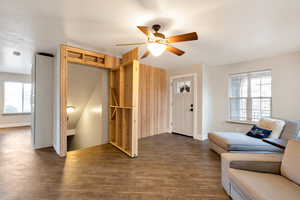 Living area featuring ceiling fan and dark wood finished floors