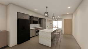 Kitchen with light countertops, a sink, a breakfast bar area, black refrigerator with ice dispenser, and high end range