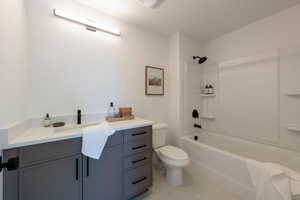 Full bathroom featuring vanity, shower / bath combination, and light tile patterned flooring