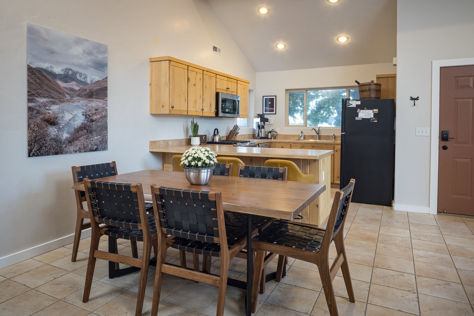 Dining area with baseboards, high vaulted ceiling, visible vents, and light tile patterned floors