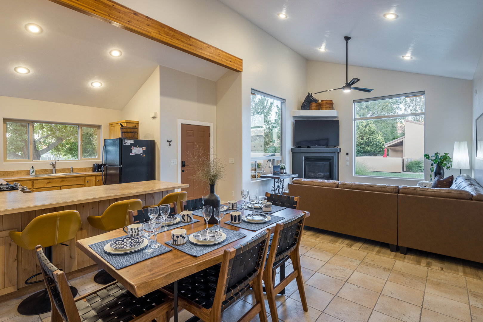 Dining space with lofted ceiling, a glass covered fireplace, recessed lighting, and a ceiling fan