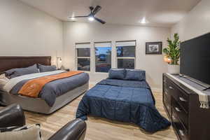 Bedroom featuring light wood-style flooring, baseboards, recessed lighting, a ceiling fan, and vaulted ceiling