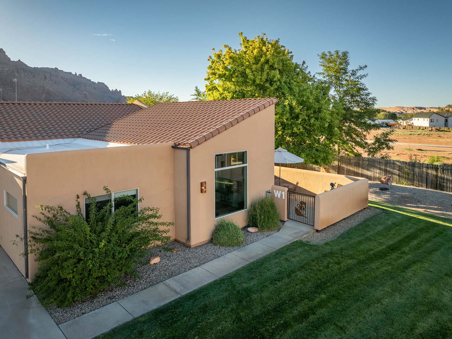 Exterior space with a lawn, stucco siding, and fence