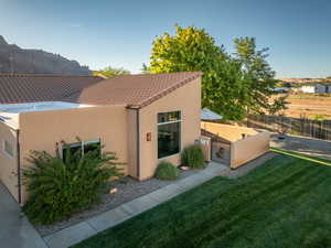 Exterior space with a lawn, stucco siding, and fence