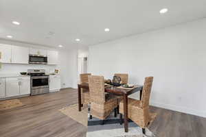 Dining area with baseboards, dark wood-style flooring, and recessed lighting