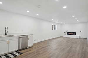 Interior space with recessed lighting, wood finished floors, a sink, and dishwasher