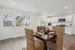 Dining area featuring baseboards, wood finished floors, and recessed lighting
