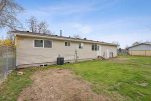Back of property with a lawn, cooling unit, fence, and entry steps