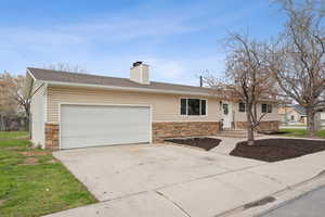 Ranch-style house featuring concrete driveway, roof with shingles, stone siding, a garage, and a chimney