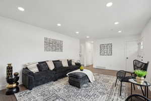 Living room featuring wood finished floors, recessed lighting, baseboards, and visible vents