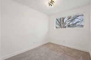 Carpeted spare room with baseboards and visible vents