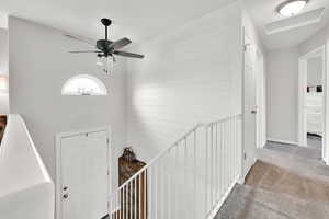 Carpeted foyer entrance featuring a ceiling fan