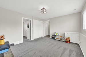 Recreation room with baseboards, visible vents, and carpet