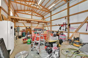 Garage with white fridge with ice dispenser and electric panel