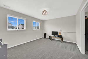 Office with baseboards, visible vents, and carpet floors