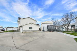 View of property exterior featuring an outbuilding, a gate, and fence