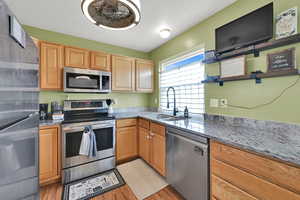 Kitchen featuring a sink, stainless steel appliances, light wood-style floors, and open shelves