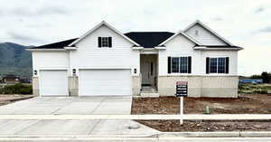 View of front of home featuring a mountain view, brick siding, and driveway