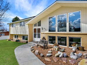 Front of house with brick siding, fence, and a yard