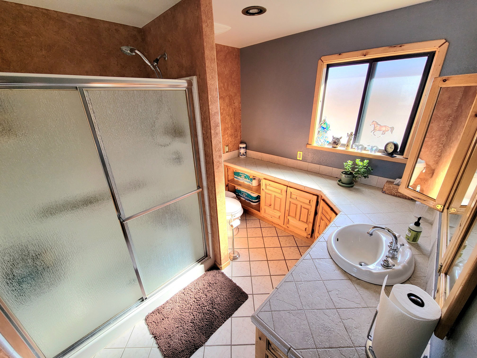 Full bath featuring tile patterned floors, a sink, and a stall shower