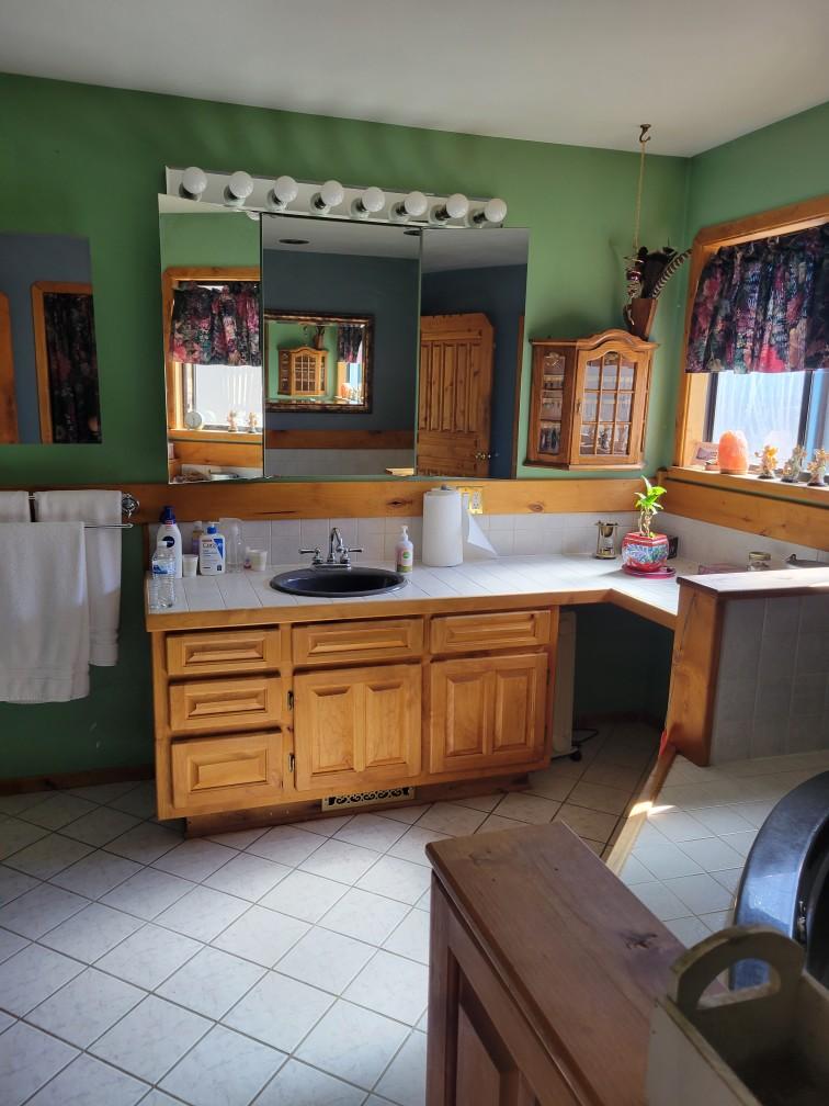 Kitchen with a sink, tile countertops, and light tile patterned flooring