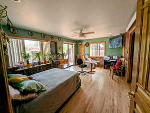 Bedroom featuring light wood-style flooring, a ceiling fan, a textured ceiling, and access to exterior