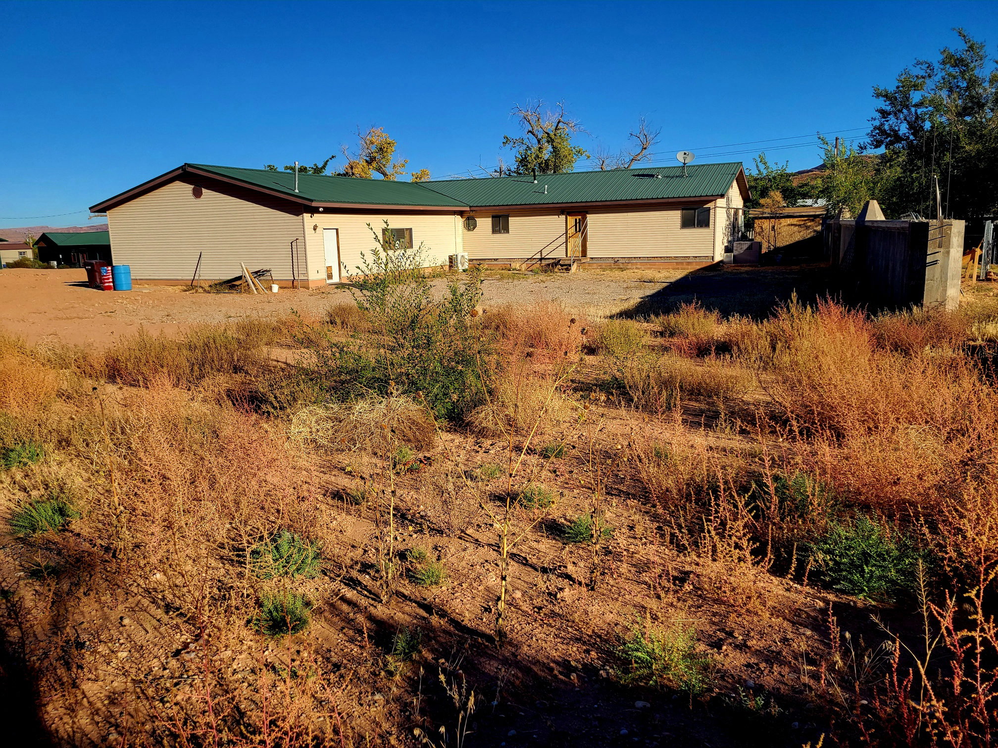 Back of house with metal roof and fence