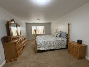 Bedroom featuring light carpet and baseboards