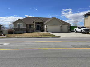 Ranch-style home with stucco siding, stone siding, a garage, and concrete driveway