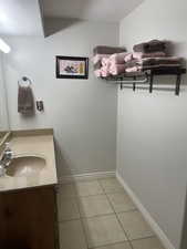 Bathroom featuring tile patterned floors, vanity, and baseboards