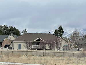 View of rear of home featuring stucco siding and fence