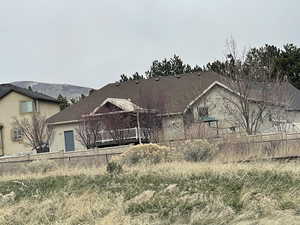 View of rear of house featuring stucco siding and fence